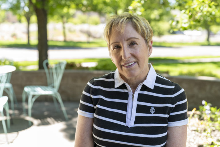 A woman wearing a black and white striped shirt, working as a dentist in Bend, Oregon.
