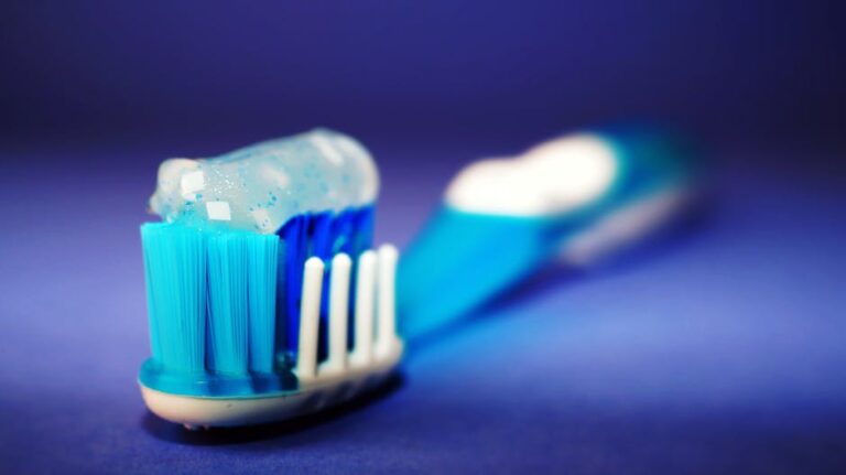 A blue and white toothbrush on a blue background.