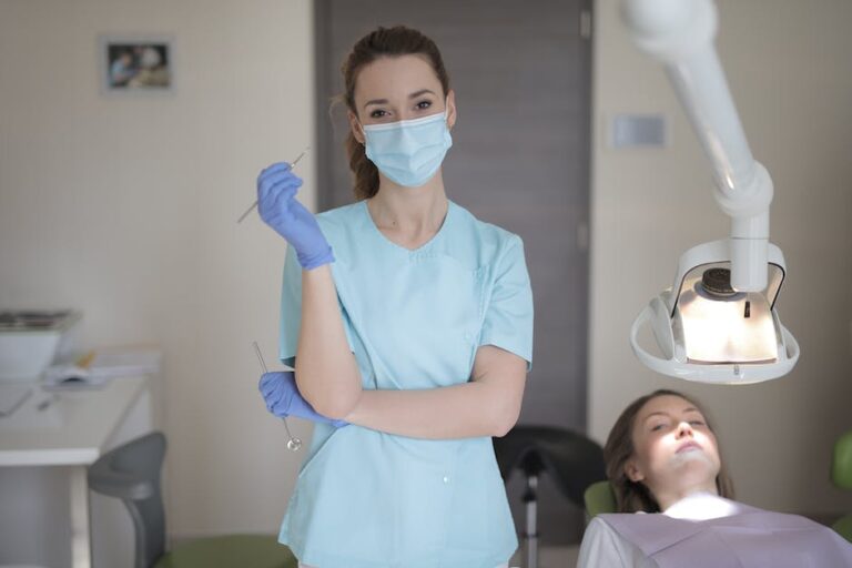 A woman in a dentist's office standing next to a patient.