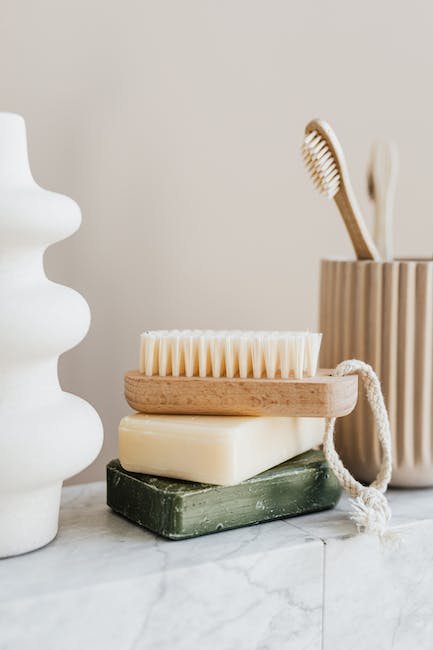 A toothbrush, soap, and a vase on a marble countertop.